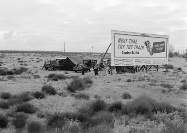 documentary-lange - 1EarthMedia Photograph by Dorothea Lange during the Great Depression. Three families camped on the plains along the U.S. 99 in California. They are camped behind a billboard which serves as a partial windbreak. All are in need of work. 1938. The billboard says: ‘Next time try the train. Southern Pacific. Travel while you sleep’