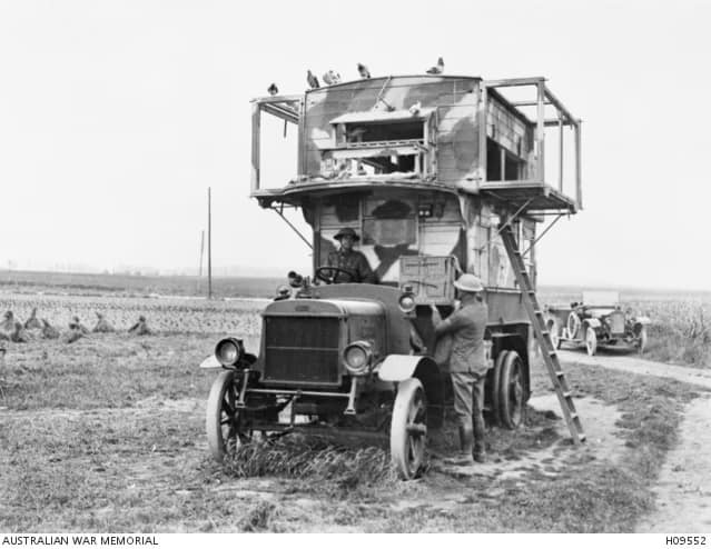 Pigeon Australian - 1EarthMedia Pernes, France, circa 1917 — A London motor bus from Putney, repurposed by the British Army as a mobile pigeon loft. The driver of the staff car behind delivers a wicker pigeon basket to the converted vehicle. (British Official Photograph L774. Australian War Memorial, Accession No. H09552)