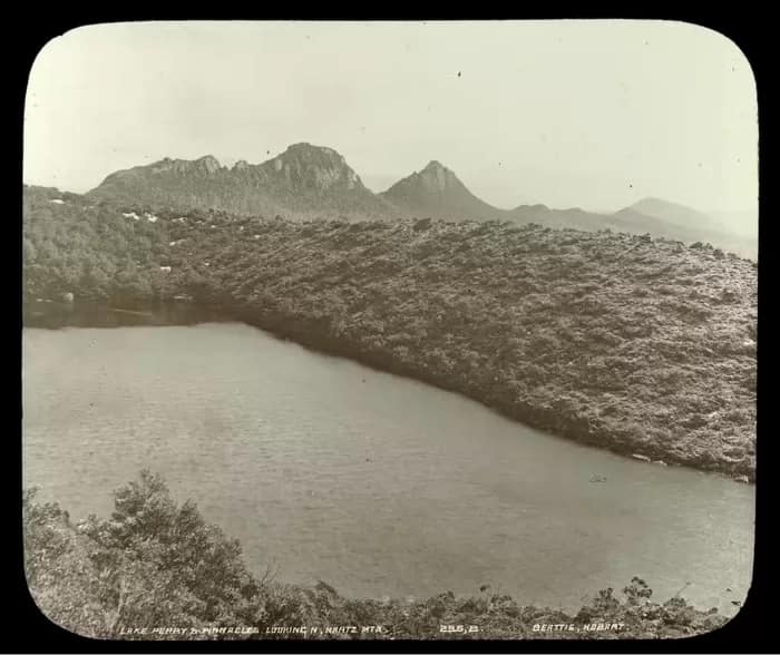 landscapephoto09-700 - 1EarthMedia This photograph of Lake Perry in the Hartz Mountains gives a good sense of the gradations of the Tasmanian highlands and the dramatic topography that attracted photographers. John Beattie, Lake Perry and Pinnacles looking Nth, Hartz Mountains, c. 1900. Glass Lantern Slide. Tasmanian Views Collection.ย State Library of Victoria