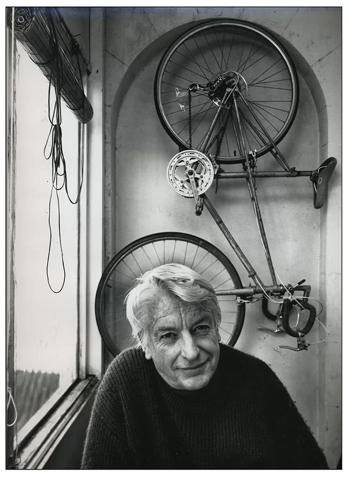 RobWallsBruce-Petty - 1EarthMedia Rob Walls photo. Cartoonist, Bruce Petty photographed at his Birchgrove, Sydney home, for a series of portraits of prominent Australians for the Good Weekend. The dangling blind cord seemed to echo Bruce’s drawing style and the hanging bicycle allowed me to portray him as the patron saint, the doyen of Australian cartoonists. T-Max 400 5x4, Toyoview Studio monorail camera, 150mm Nikkor. 1988