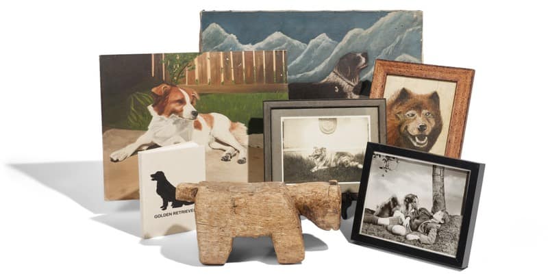 Diane Keaton home - 1EarthMedia Group of dog photo frames and a small carved wooden dog figurine arranged on a white surface.